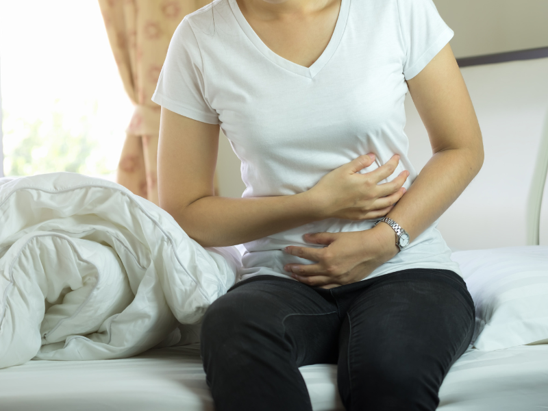 Traveler experiencing stomach pain and seeking bali belly medication for digestive recovery.
